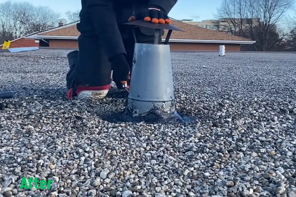 Flat-roof pipe penetration during repair, with a roofer applying compatible repair material