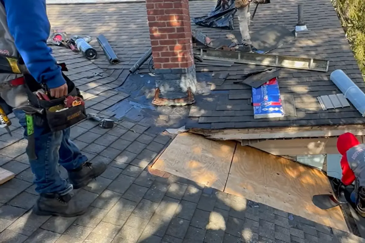 Before repair: damaged asphalt shingles removed to expose roof decking during a shingle roof repair